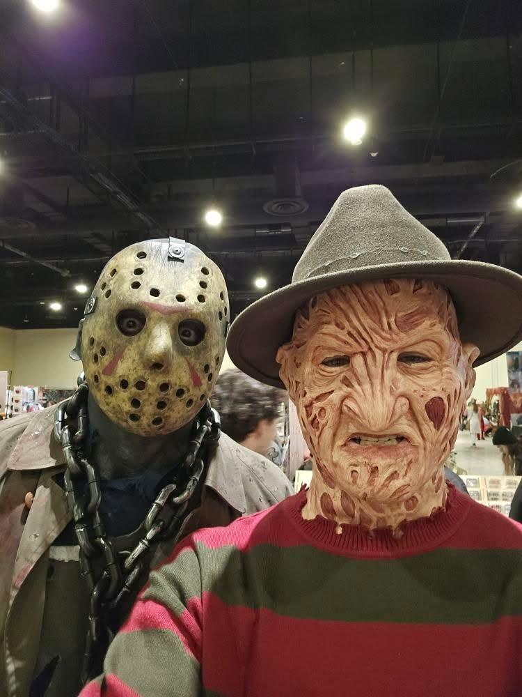 Nicolas in a masked costume with a friend dressed as another horror character